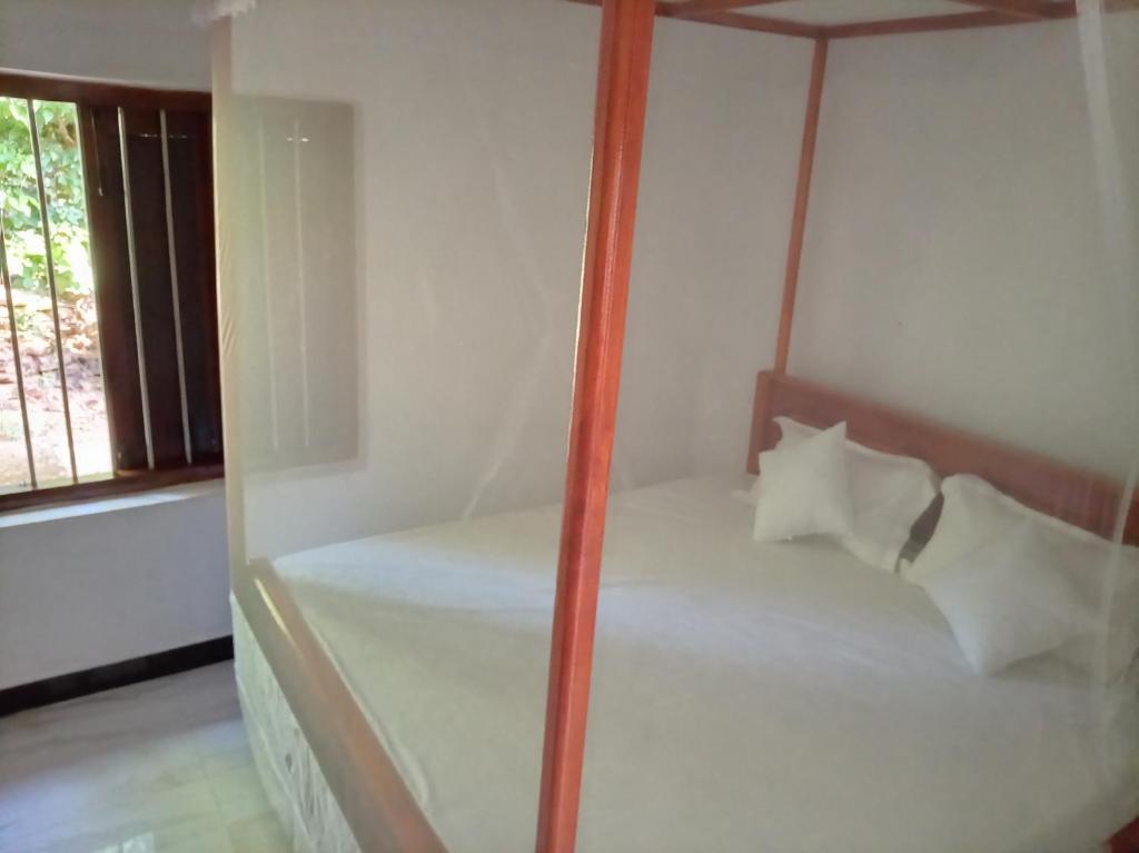 a bedroom with a bed with a glass wall at White Shell in Tangalle