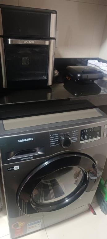 a microwave oven sitting on top of a washing machine at Maison Chateaubriand Residence in Maceió