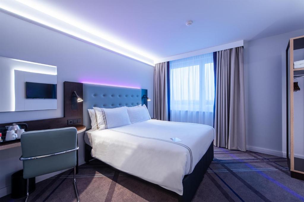 een hotelkamer met een groot bed en een bureau bij Premier Inn Muenchen Messe in Haar