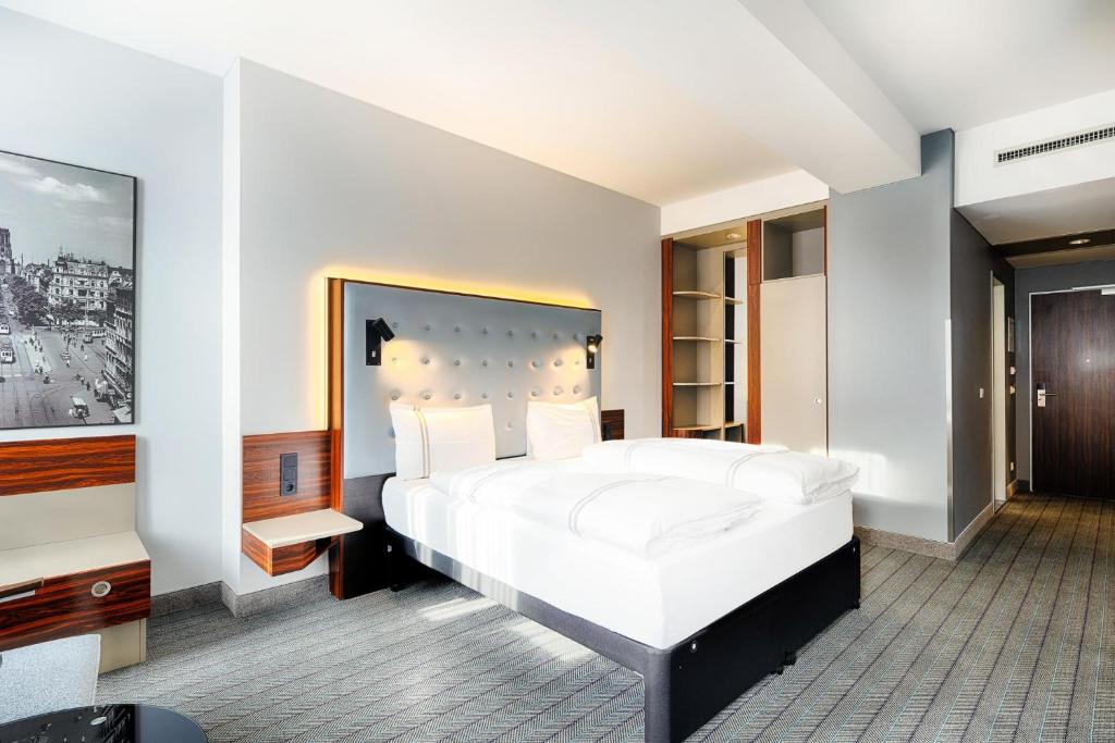 een slaapkamer met een groot wit bed en een tv bij Premier Inn Köln City Mediapark in Keulen