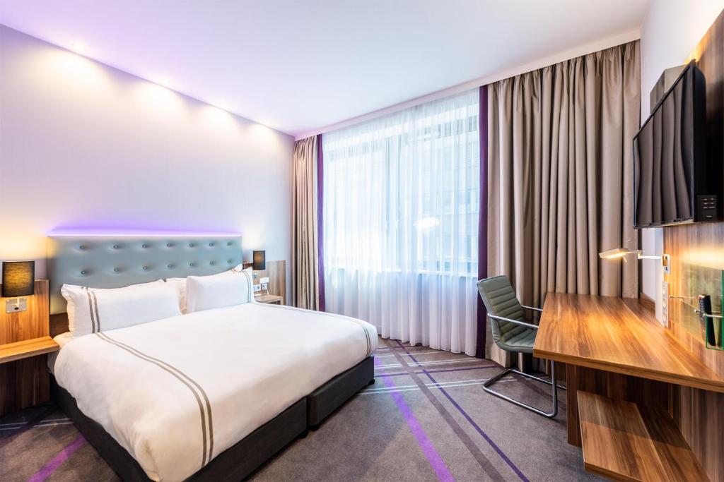a hotel room with a bed and a desk at Premier Inn Frankfurt City Centre in Frankfurt/Main