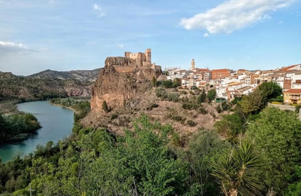 eine Burg auf einem Hügel neben einem Fluss in der Unterkunft Exclusivo Apartamento COFRENTES in Cofrentes