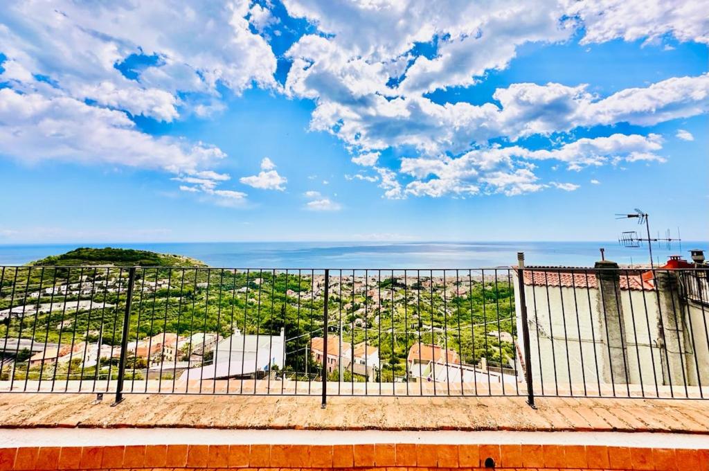 Blick auf eine Stadt von hinter einem Zaun in der Unterkunft Dimora Concept - Casa Saracena - Sea View, Terrace and Free Parking in Ranzi