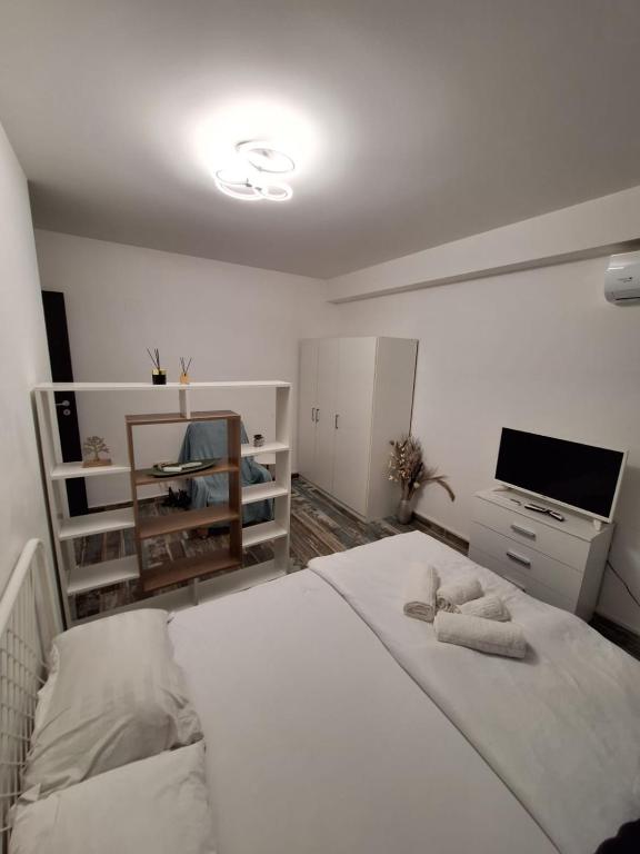 a bedroom with a white bed and a television at Petit Blue in Dudu