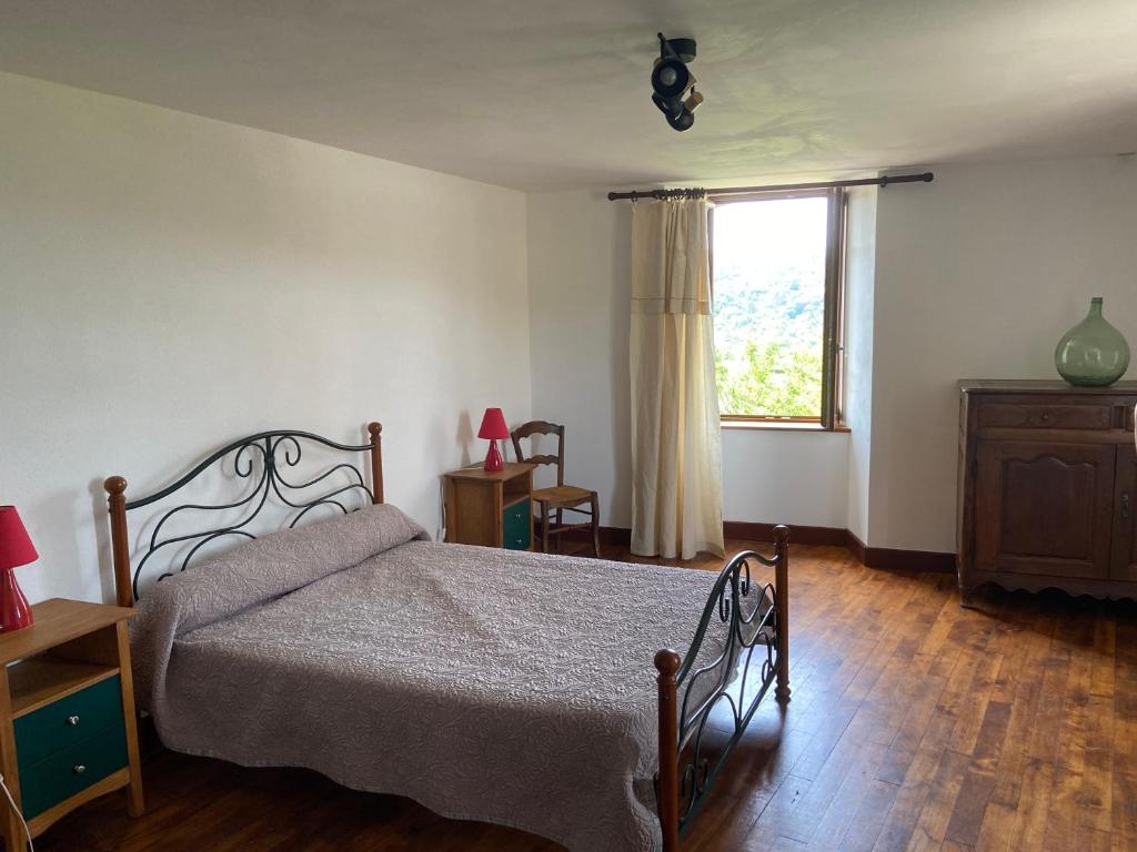 un dormitorio con una cama y una ventana en Le gîte de caractère, en Flagnac