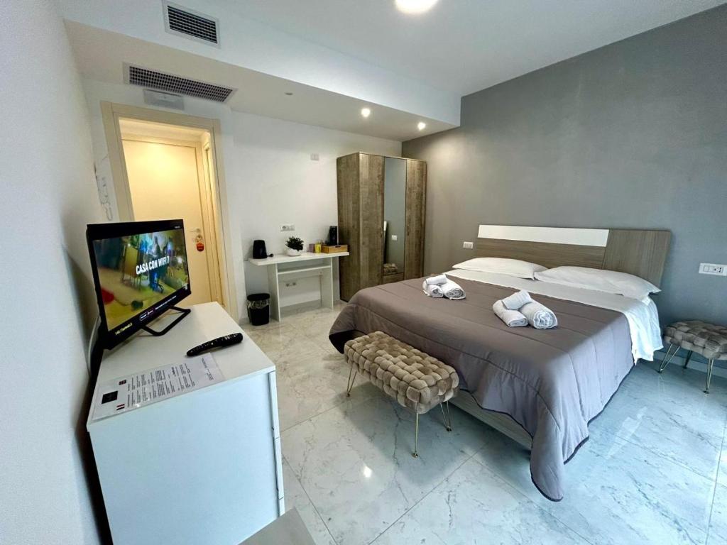 Un dormitorio con una cama y un televisor. en Aqua Marine B&B - Rooms and Apartments, en Milazzo