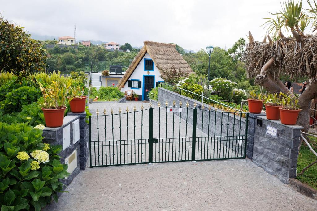 a black gate with potted plants in front of a house at Casa da Mãe in Santana