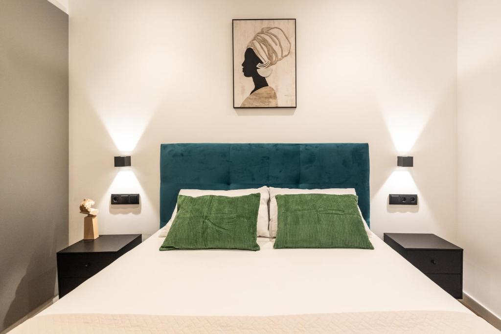 una camera da letto con un grande letto bianco con cuscini verdi di Cielo y Mar a Valencia