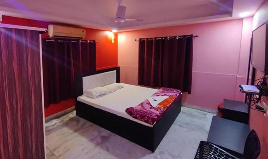 a bedroom with a bed with red walls and curtains at FabHotel Rose in kolkata