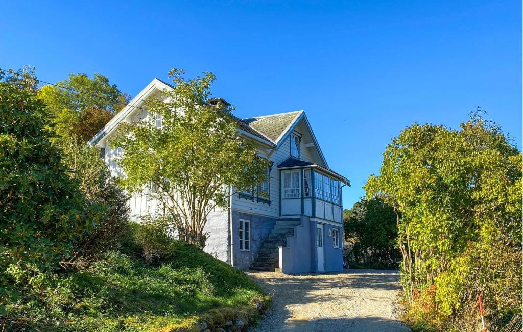a blue and white house on a hill with trees at Beautiful Home In Vistdal With Wifi in Myklebostad