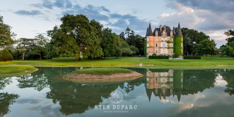 een kasteel met zijn reflectie in het water bij Château D'Apigné Rennes in Le Rheu