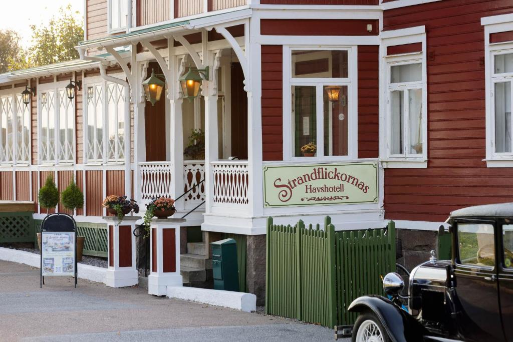 een oude auto geparkeerd voor een huis bij Strandflickornas Havshotell Lysekil in Lysekil