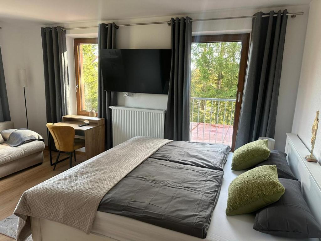 a bedroom with a bed and a large window at Pension Zollhaus in Oy-Mittelberg
