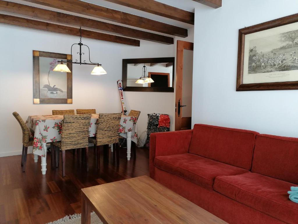 a living room with a red couch and a table at Esterri Confort in Esterri d'Àneu
