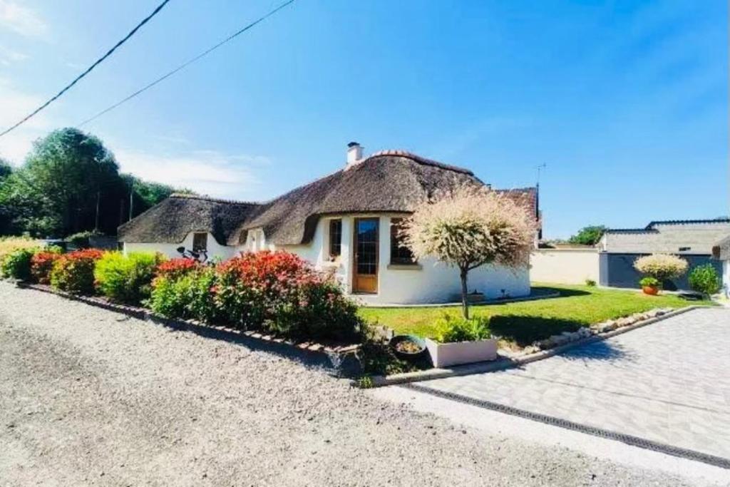 a cottage with a thatched roof on a driveway at La Chaumière des 2 Cygnes-SPA- WIFI-Parking-Calme in Abbeville