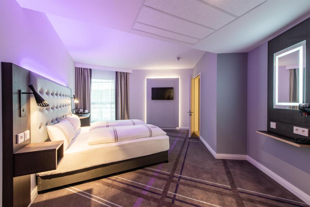 een slaapkamer met paarse muren en een groot bed bij Premier Inn Stuttgart Feuerbach in Stuttgart