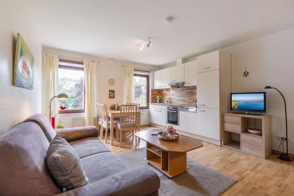 una sala de estar con un sofá y una mesa en Ferienwohnung 1, en Todendorf auf Fehmarn