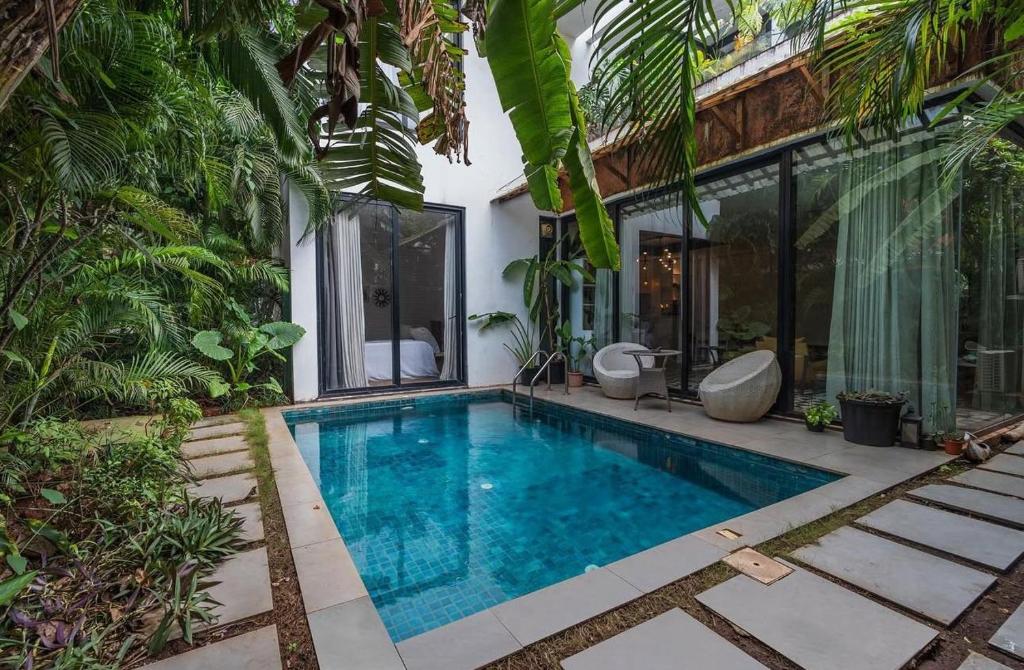 a swimming pool in the backyard of a house at 3 Bedroom Private Pool Villa in North Goa by Amorey Stays in Vagator