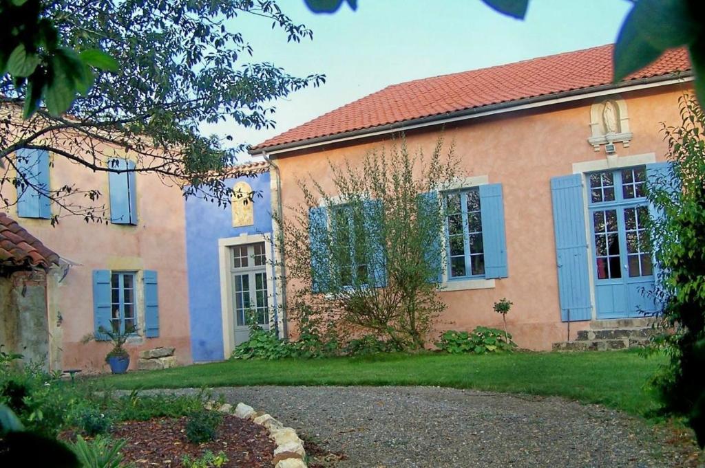 una casa con persianas azules y un patio en La masqueria, en Montgaillard