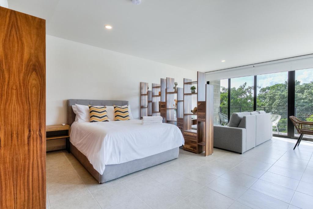 een slaapkamer met een groot bed en een stoel bij Great location depto with Gym in Cancun