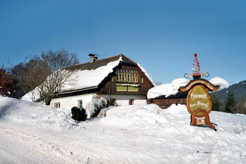 a large wooden barn with a sign in the snow at Hoamatlhütte in Schladming