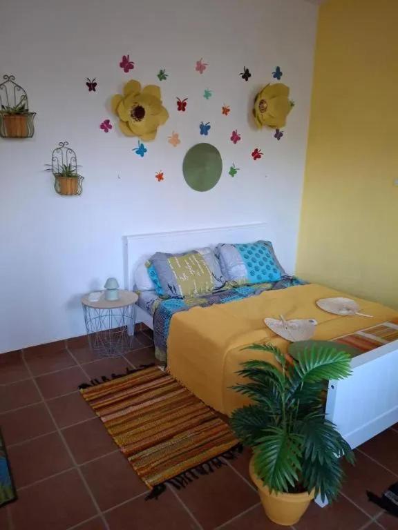 a bedroom with a bed with flowers and planets on the wall at Maison accueillante à Sainte-Rose, 25 m² et balcon in Duzer