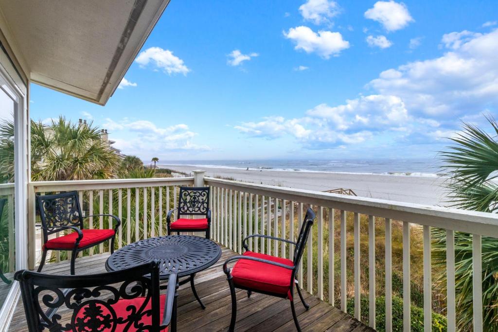a balcony with chairs and a table and a view of the beach at SG10C: 10C Seagrove Villa in Isle of Palms