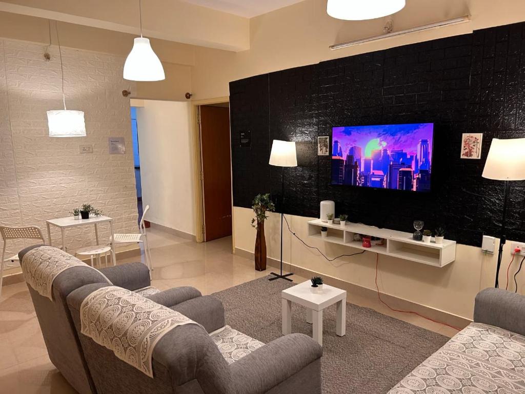 a living room with a couch and a flat screen tv at Electrifying 2BHK Gateways in Bengaluru