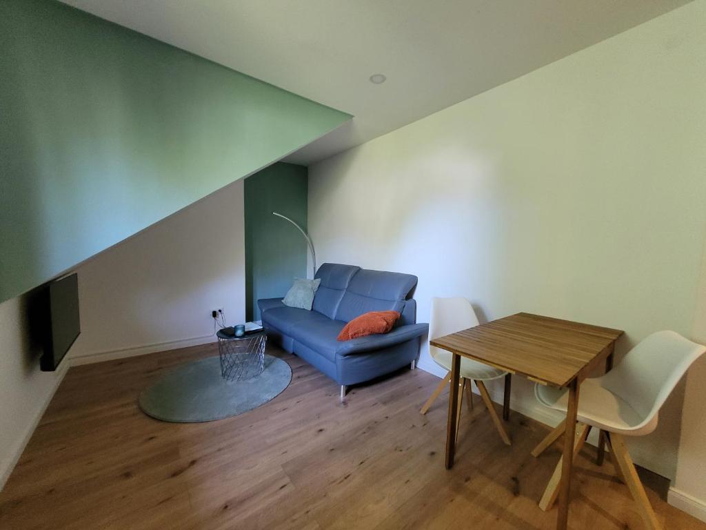 a living room with a blue couch and a table at Reload Apartments - FeWo3 im Remmeker Feld in Bad Arolsen