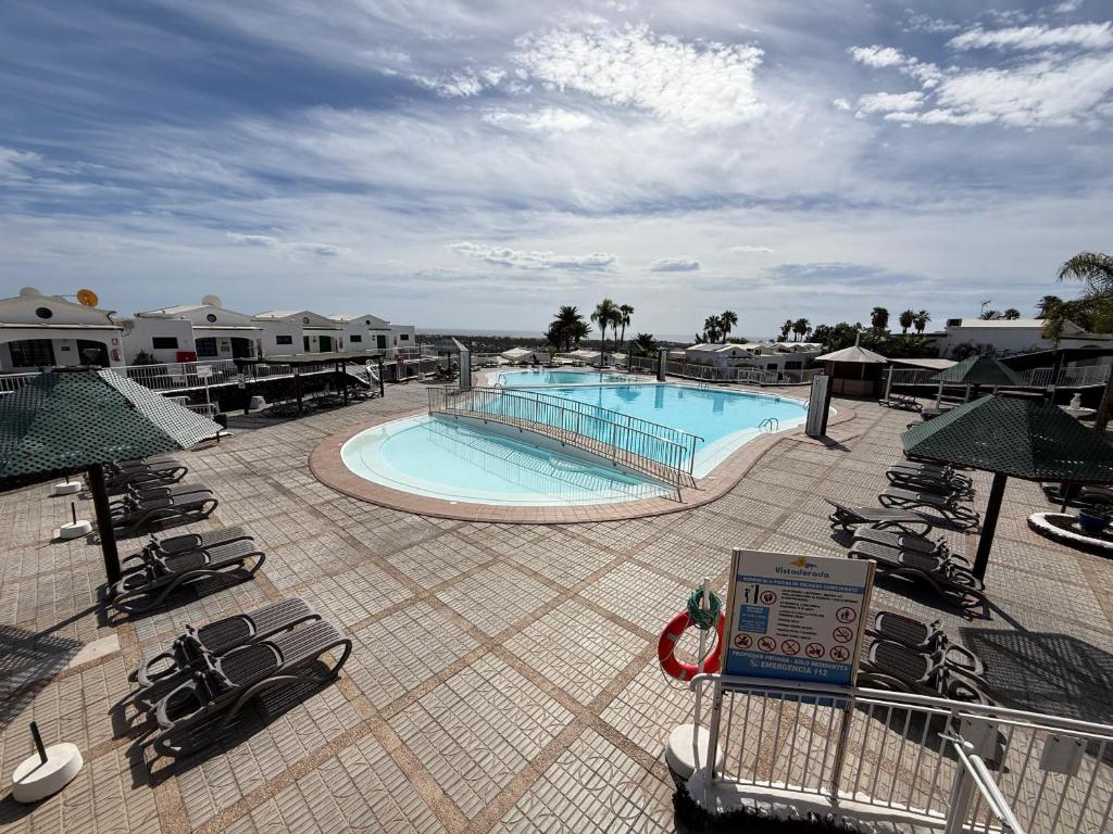 a swimming pool in a resort with lounge chairs at Vista Dorada in Sonnenland