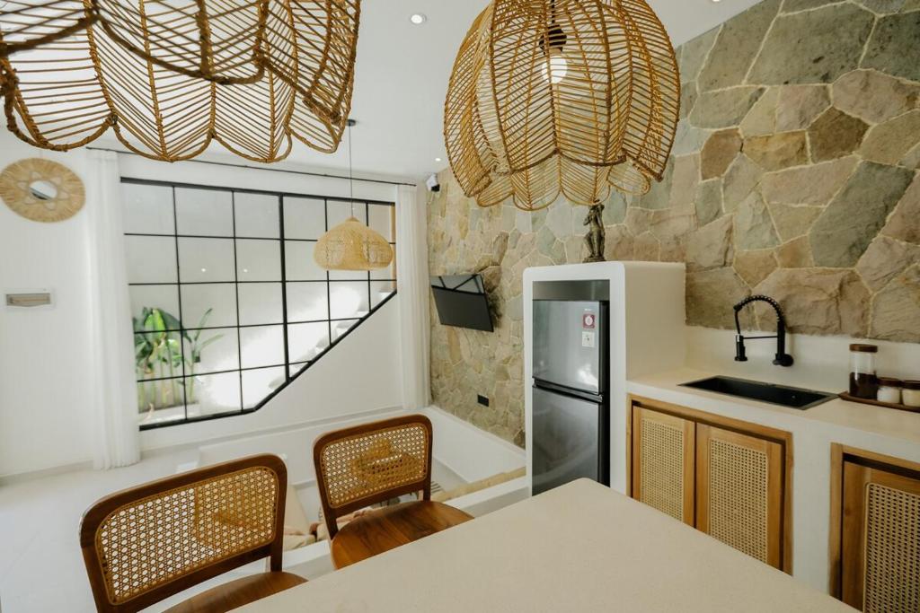 a kitchen with a table and chairs and a refrigerator at Villas Tamu 1 in Bingin Beach