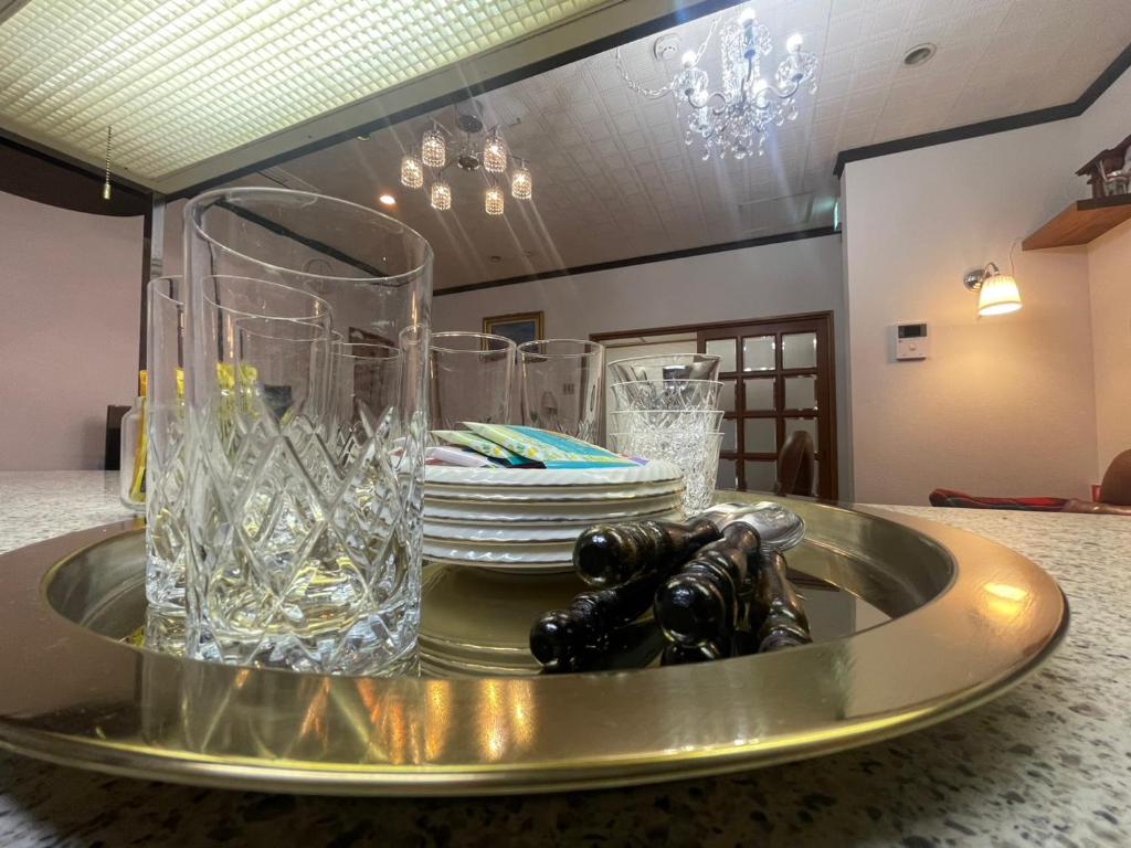 ein Tablett mit Gläsern und Tellern auf dem Tisch in der Unterkunft Cornell Airport Station Pickup Dropoff in Kishiwada