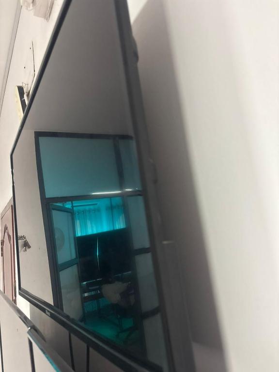 a reflection of a person sitting in a chair in a window at De beachside Villa in Virāmpattinam