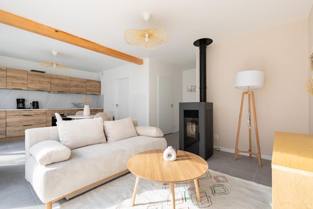 a living room with a white couch and a table at Jolie maison de style bohème, douce et lumineuse in Bordeaux