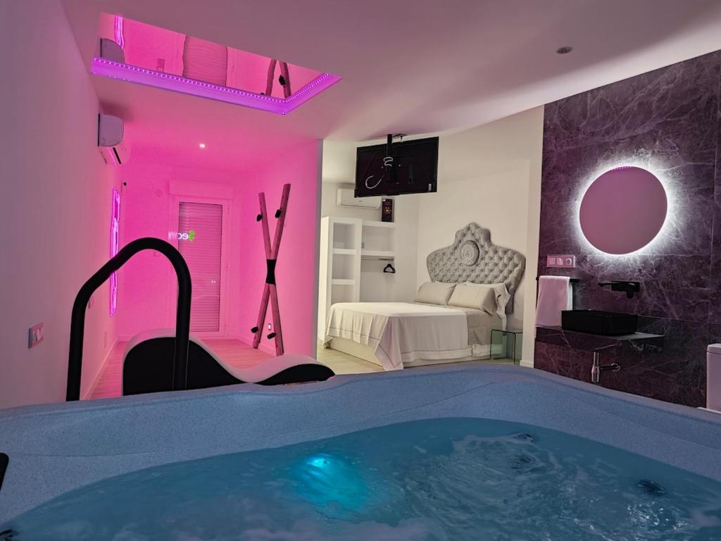 a bathroom with a tub in a room with a bed at Secrets Torrevieja in Torrevieja