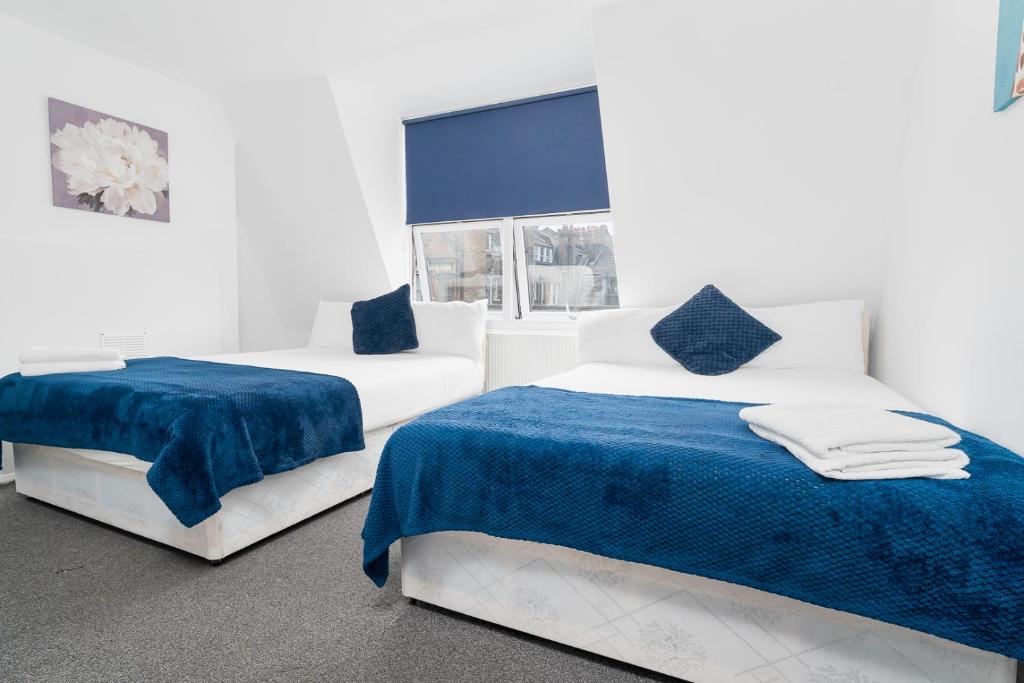 Russel Square Rooms في لندن: غرفة بيضاء بسريرين ونافذة