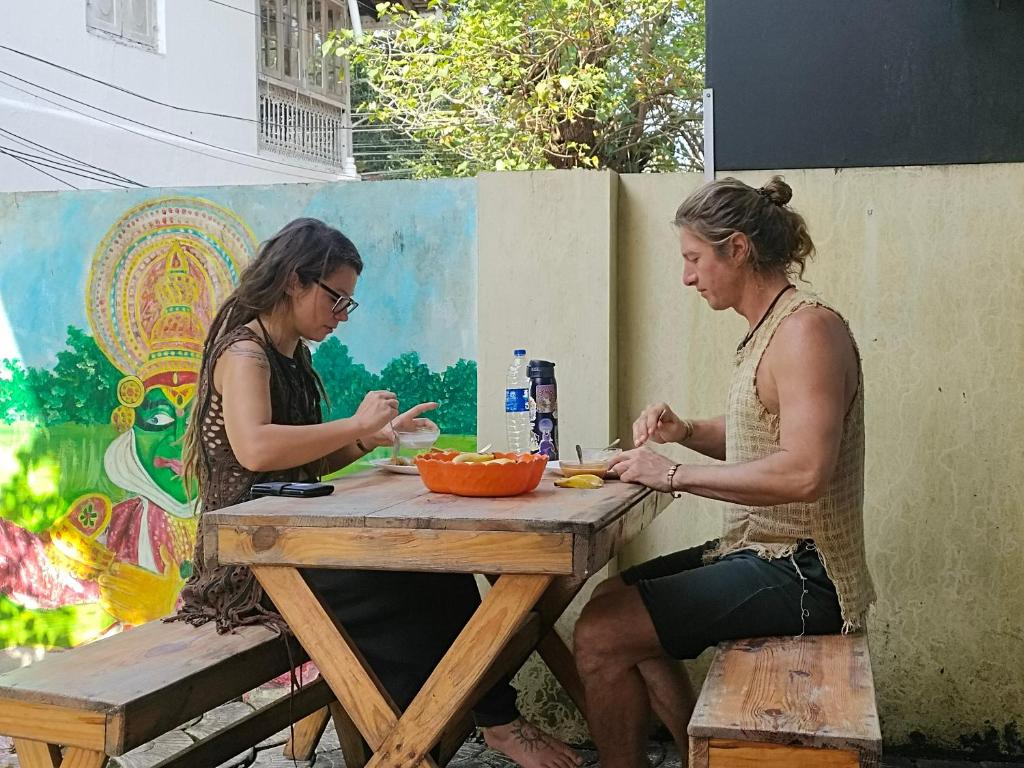 two women sitting at a picnic table eating food at Kochi Bella Villa in Cochin