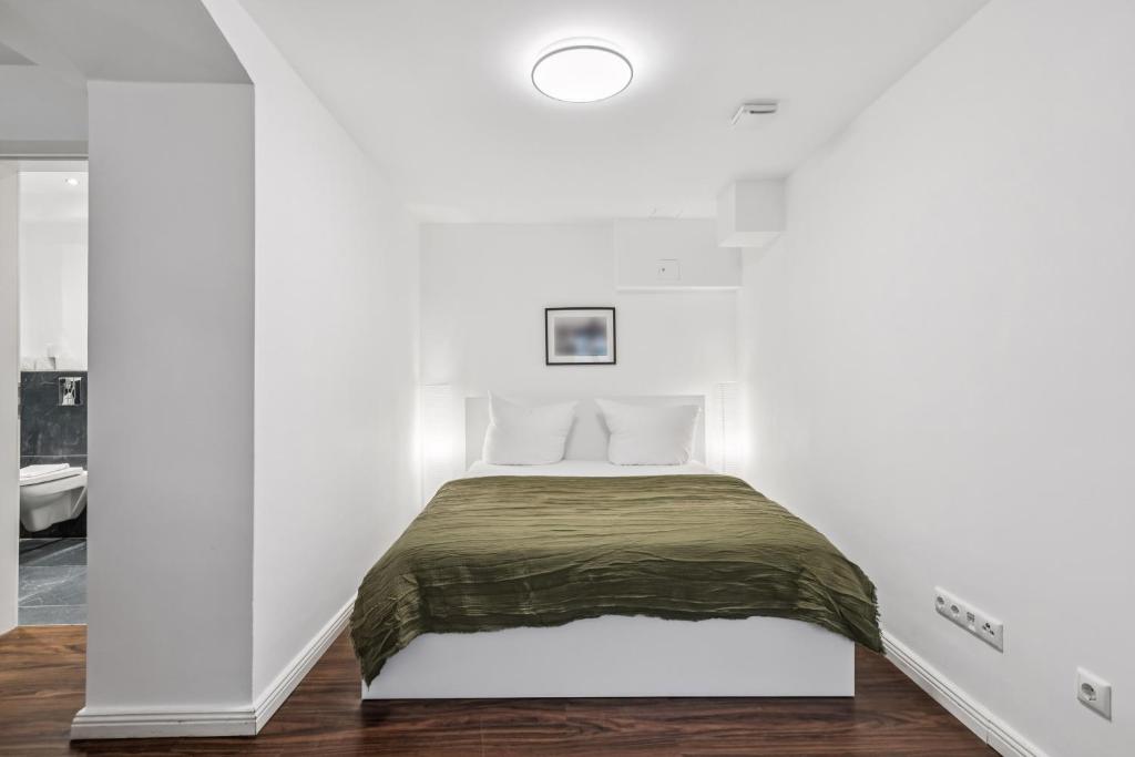 a bedroom with a bed in a white room at Arbio I Stylish Apart Schöneberg S-Bahn in Berlin