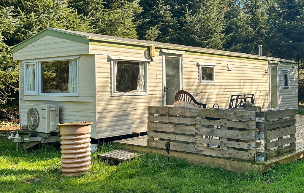 une petite maison assise au-dessus d'une terrasse en bois dans l'établissement 3 Bedroom Nice Home In Nexø, à Balke