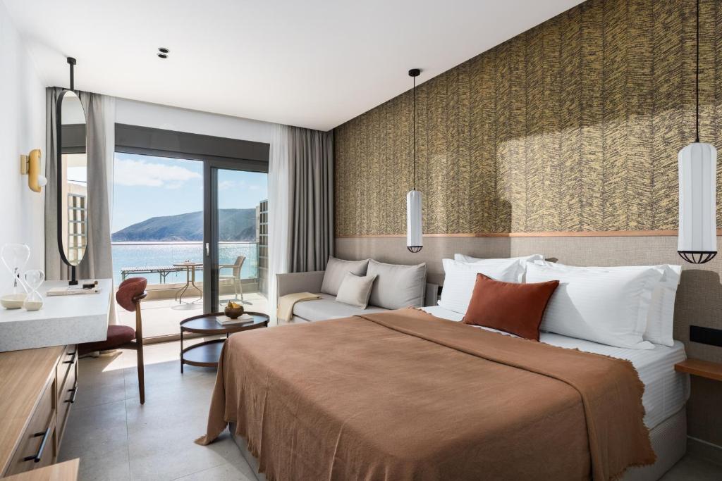 a hotel room with a bed and a view of the water at Orizon Boutique Rooms in Kalamitsi