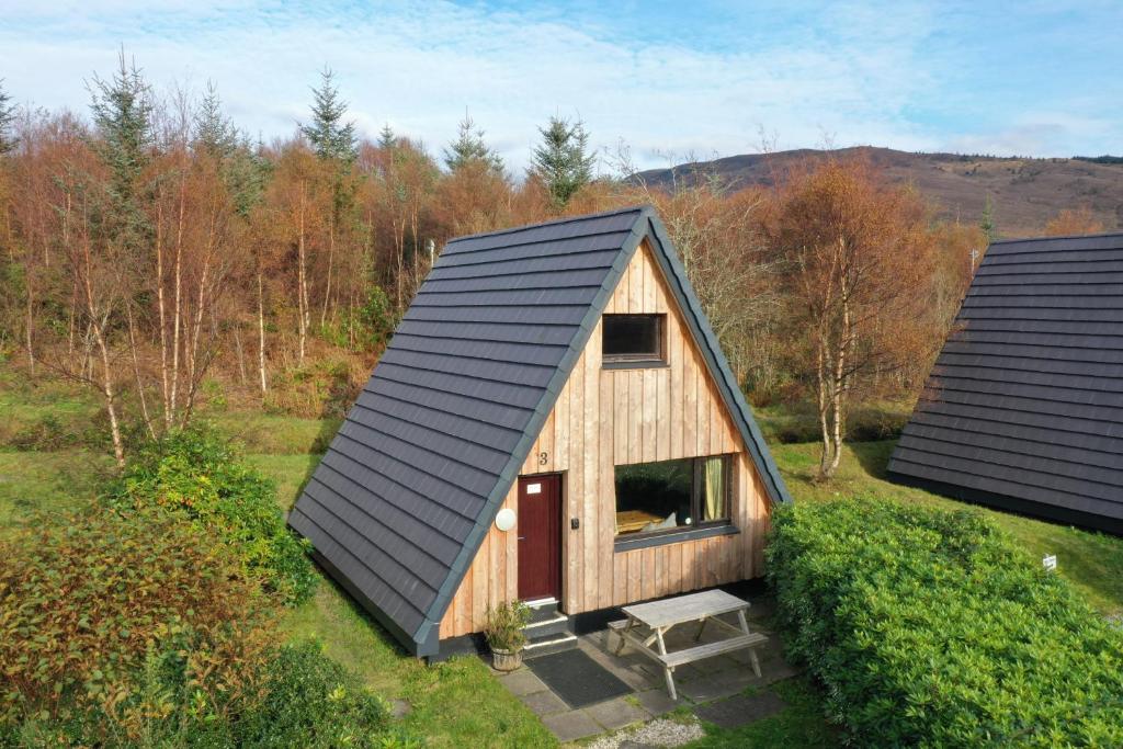 an overhead view of a wooden cabin with a black roof at 1 Bedroom Cabin with Mountain & Loch Views - Quiet Location between Glencoe & Ben Nevis in Onich