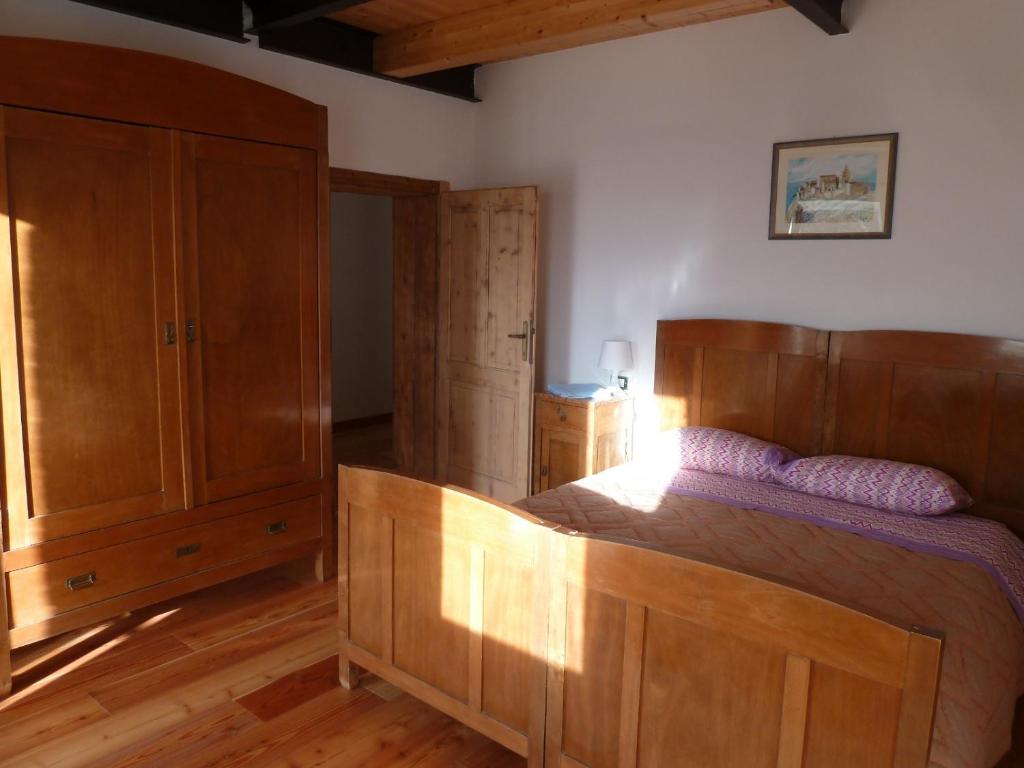 une chambre avec un lit et une armoire en bois dans l'établissement Camere per Olimpiadi di Cortina 2026, à Col