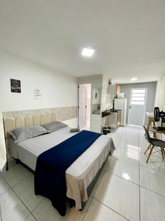 een slaapkamer met een groot bed en een keuken bij Studio 107 in Sao Paulo