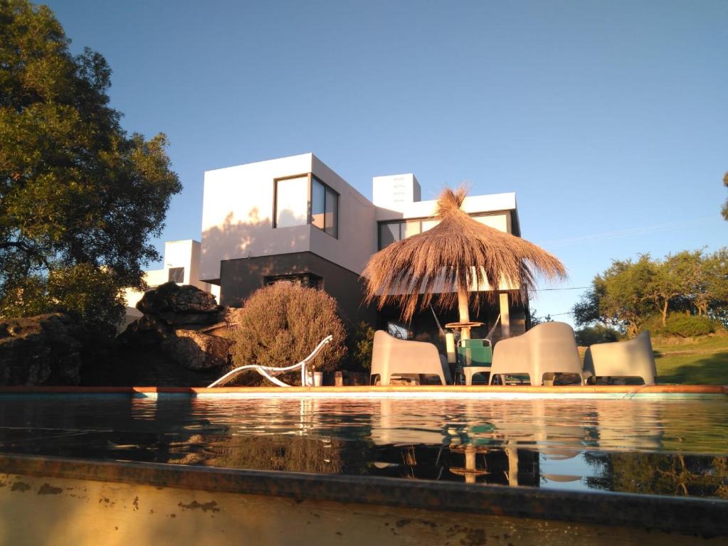 een huis met een zwembad ervoor bij CuyenCo Casa de campo in Santa Rosa de Calamuchita