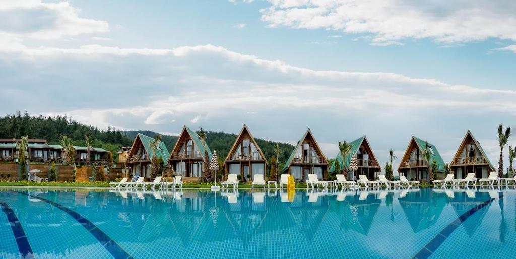 een rij huisjes naast een groot zwembad bij Bisanthe Panorama in Kumbağ