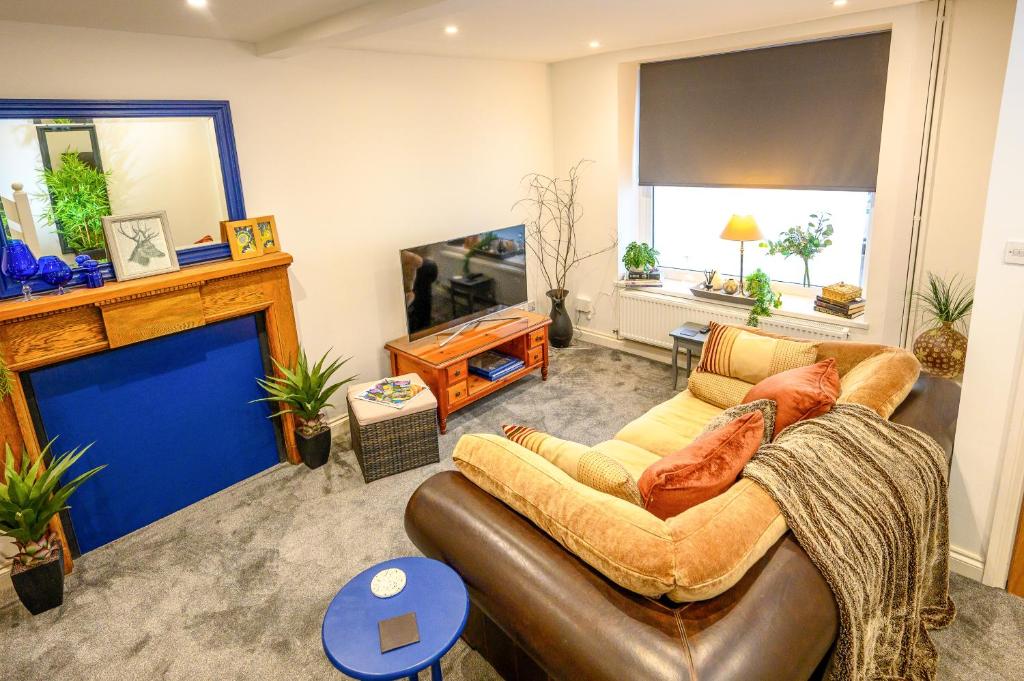 a living room with a couch and a television at James Terrace by STAE Homes in Porth