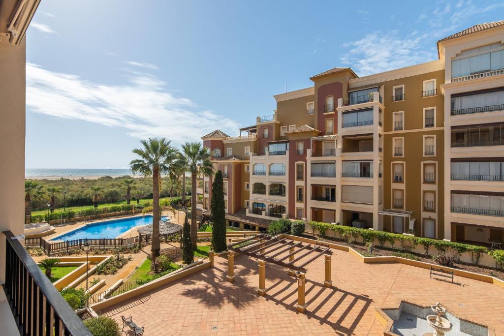 an apartment building with a pool and palm trees at Playa Grande by H- Playa Punta del Moral PPHG136P111 in Isla del Moral