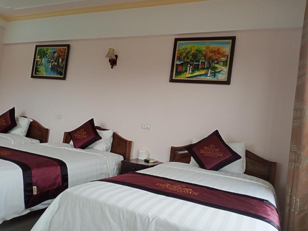 - 2 lits dans une chambre d'hôtel ornée de peintures murales dans l'établissement Khách Sạn Thành Loan 2, à Nà Phia