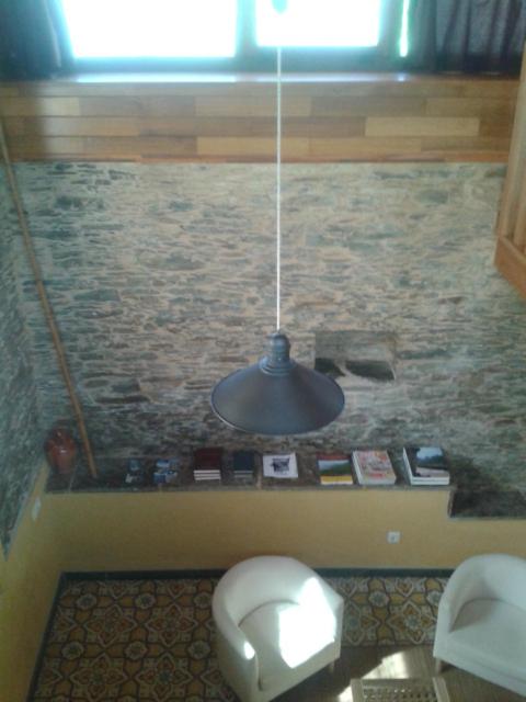 a bathroom with a toilet and a hanging light at A Cabana de Cao in Loiba