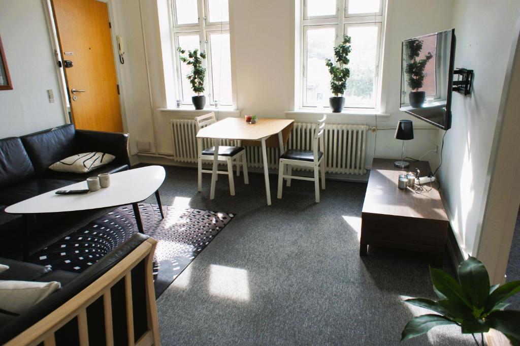 a living room with two tables and two windows at Id069 Englandsgade 13, 1th in Esbjerg